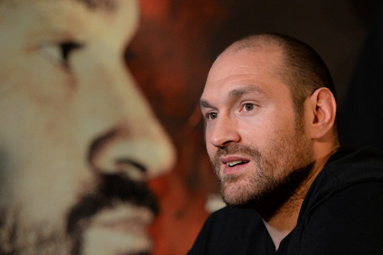British heavyweight boxer Tyson Fury speaks during a press conference to publicise his forthcoming world heavyweight title fight against Ukranian heavyweight Wladimir Klitschko, at the Manchester Arena in Manchester, north-west England on April 27, 2016. Wladimir Klitschko has insisted he was "glad" to have lost his world heavyweight titles to Tyson Fury in December 2015, ahead of a re-match with the British boxer on July 9, 2016. With Klitschko's loss to Fury, the belts are now spread far and wide, with Fury holding the WBA and WBO titles, fellow Briton Anthony Joshua the IBF champion, and Deontay Wilder of the United States, the World Boxing Council's heavyweight title. / AFP PHOTO / OLI SCARFF
