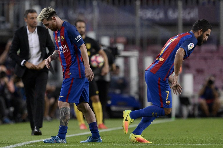 Barcelona's Argentinian forward Lionel Messi (L) leaves the pitch after being injured beside Barcelona's Turkish midfielder Arda Turan during the Spanish league football match FC Barcelona vs Atletico de Madrid at the Camp Nou stadium in Barcelona on September 21, 2016. AFP