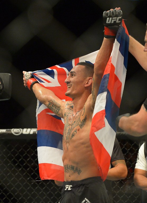 Max Holloway raises his arms after winning his featherweight bout at UFC 199 at The Forum on June 4, 2016 in Inglewood, California.   Jayne Kamin-Oncea/Getty Images/AFP