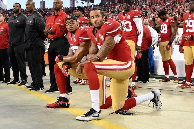 SANTA CLARA, CA - SEPTEMBER 12: Colin Kaepernick #7 and Eric Reid #35 of the San Francisco 49ers kneel in protest during the national anthem prior to playing the Los Angeles Rams in their NFL game at Levi's Stadium on September 12, 2016 in Santa Clara, California. Thearon W. Henderson/Getty Images/AFP