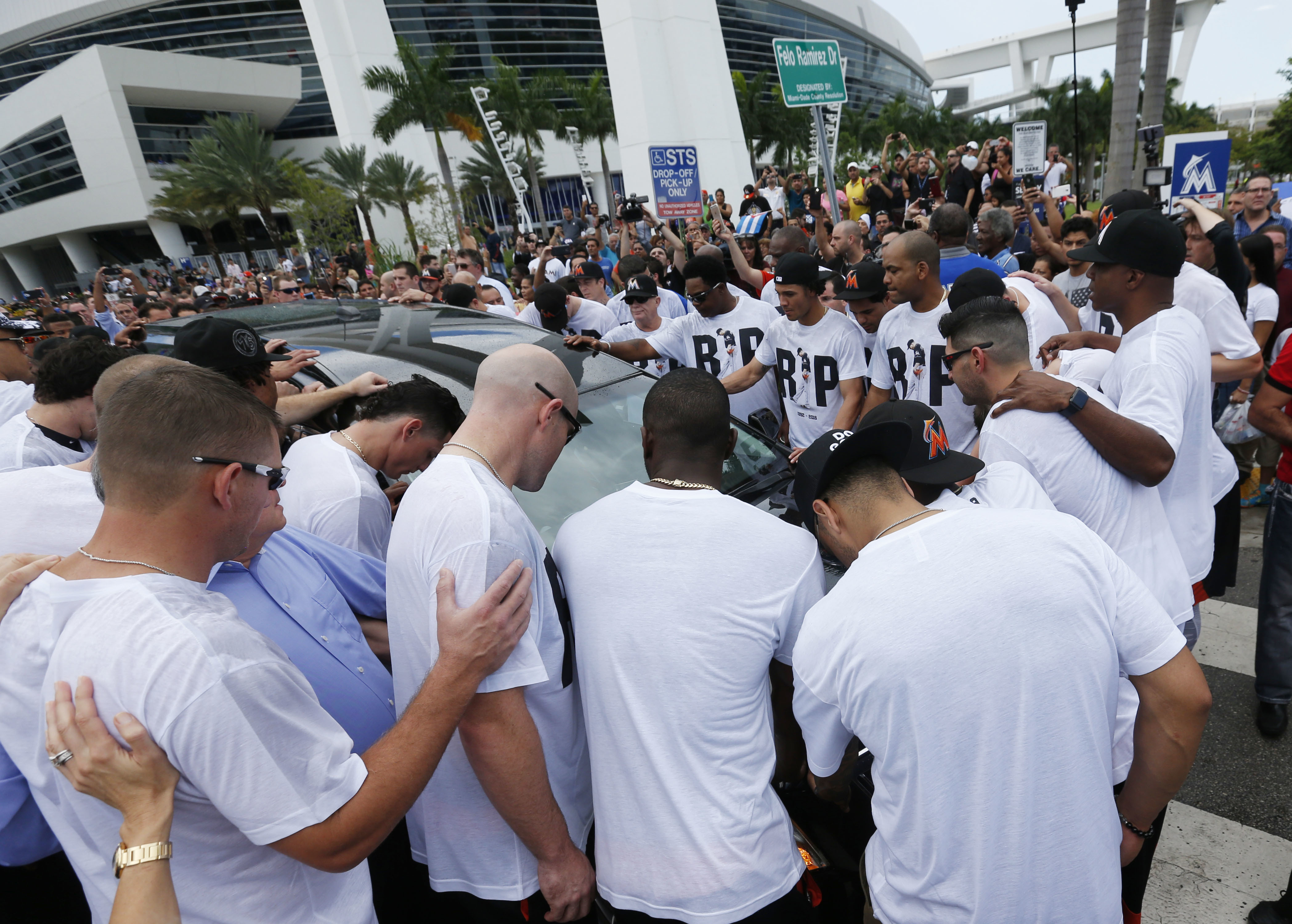 Somber Miami Marlins players and staff surround a hearse carrying the body of pitcher Jose Fernandez as it leaves Marlins Park stadium, Wednesday, Sept. 28, 2016, in Miami. AP