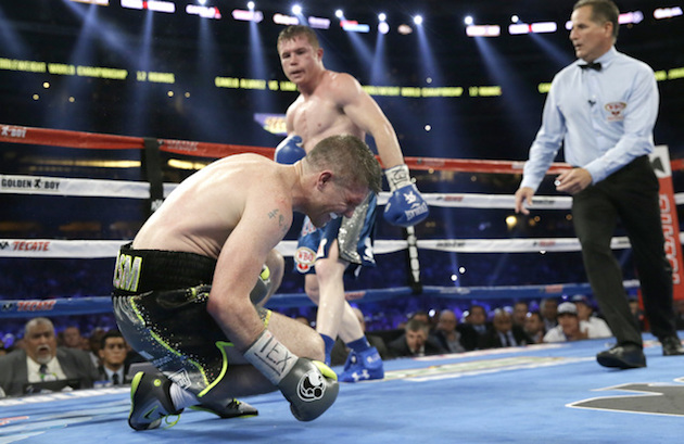 Liam Smith, left, falls to the mat after taking a body shot and being knocked out buy Canelo Alvarez fight during the ninth round of the WBO Junior Middleweight Championship boxing match at the stadium in Arlington, Texas, Saturday, Sept. 17, 2016. AP