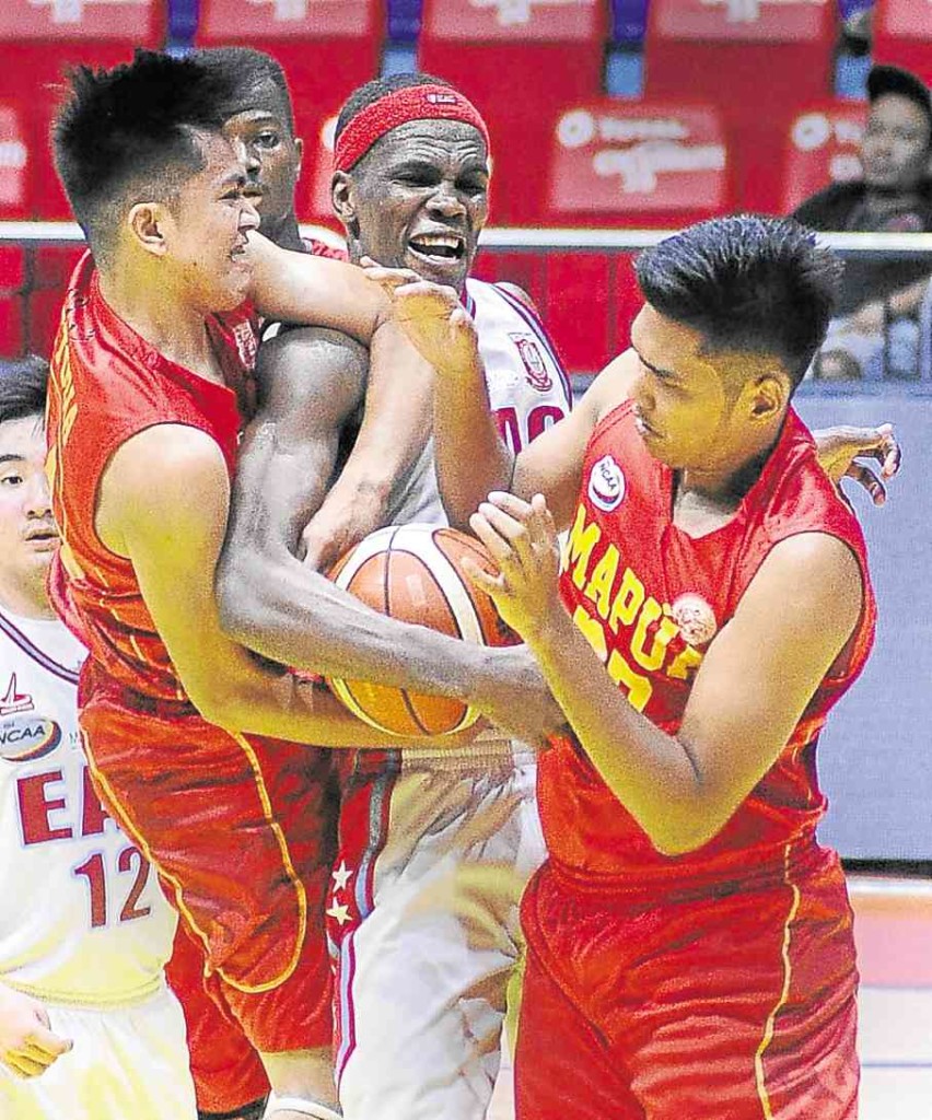 HAMADOU Laminou of EAC (center) engages Andrew Estrella (left) and Justin Serrano of Mapua in a fierce battle for possession.  AUGUST DELA CRUZ