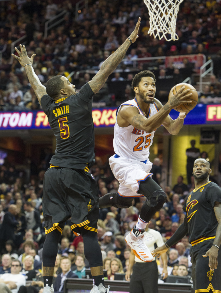 New York Knicks' Derrick Rose (25) drives past Cleveland Cavaliers' J.R. Smith (5) as the Cavaliers LeBron James watches during the first half of an NBA basketball game in Cleveland, Tuesday, Oct. 25, 2016. (AP Photo/Phil Long)