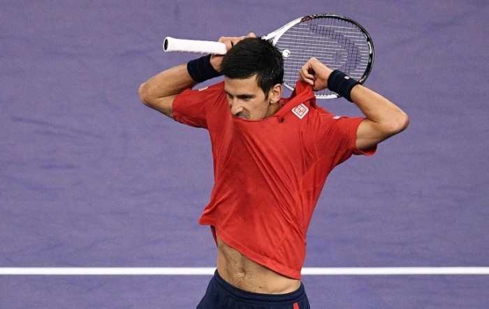 Novak Djokovic of Serbia changes his shirt after losing a point against Roberto Bautista Agut of Spain in their men's singles semi-finals match at the Shanghai Masters tennis tournament in Shanghai on October 15, 2016. / AFP PHOTO / JOHANNES EISELE
