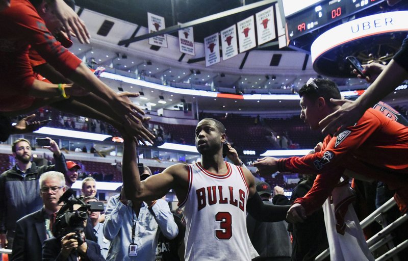 In his first game with the team, Chicago Bulls guard Dwyane Wade (3) greets fans after an NBA basketball game against the Boston Celtics Thursday, Oct. 27, 2016, in Chicago. The Chicago Bulls won 105-99. AP