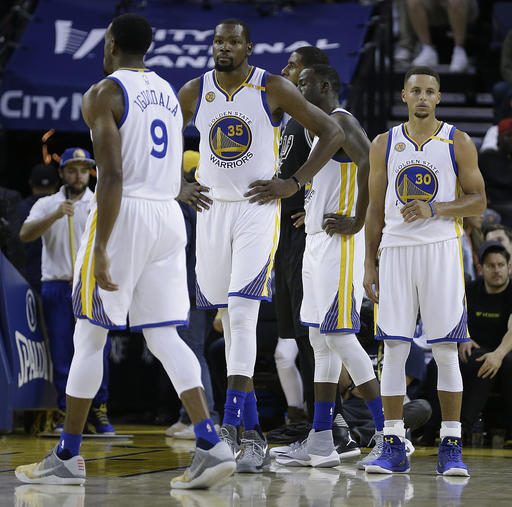 Golden State Warriors, from left, Andre Iguodala (9), Kevin Durant (35) and Stephen Curry (30) wait during a called foul during the second half of an NBA basketball game against the San Antonio Spurs on Tuesday, Oct. 25, 2016, in Oakland, Calif. AP PHOTO