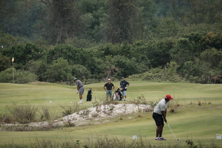 Golfers play on the Olympic golf course, created and used for Rio 2016 Olympic games and now run by the Brazilian Golf Confederation for the public, in Rio de Janeiro, Brazil, on November 23, 2016. / AFP PHOTO / YASUYOSHI CHIBA