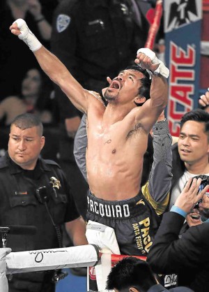 TRIUMPHANT  Filipino boxing superstar-turned-senator Manny Pacquiao celebrates after wresting the WBO welterweight championship title from Mexico’s Jessie Vargas at Thomas & Mack Center in Las Vegas, Nevada. Another Filipino, Nonito Donaire, lost his title. —AFP