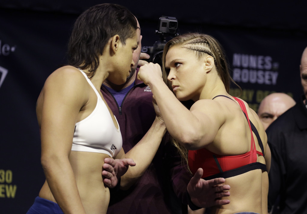 Ronda Rousey, right, and Amanda Nunes face off for photographers during an event for UFC 207, Thursday, Dec. 29, 2016, in Las Vegas. Rousey is scheduled to fight Nunes in a mixed martial arts women's bantamweight championship bout Saturday in Las Vegas. (AP Photo/John Locher)
