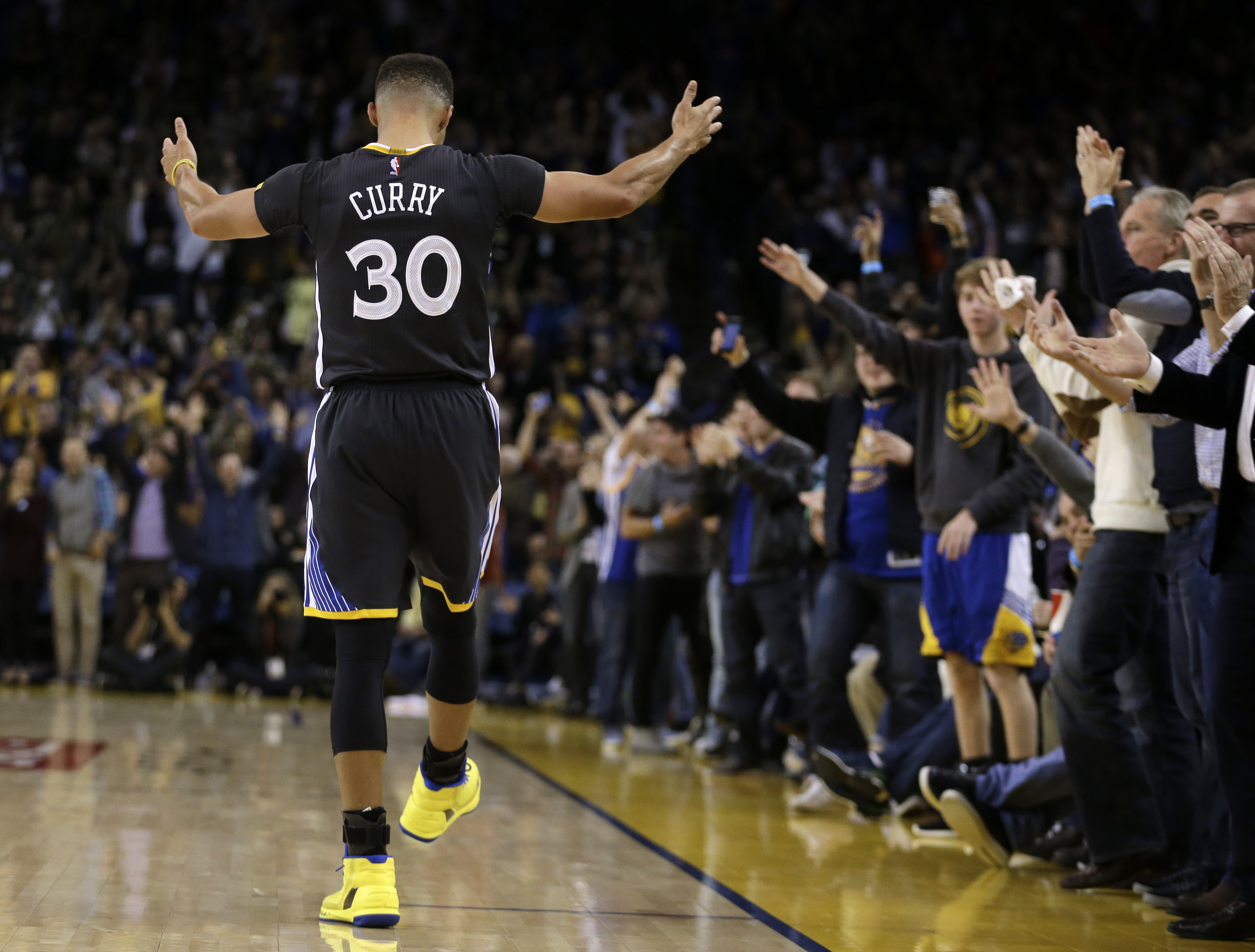 Golden State Warriors' Stephen Curry (30) gestures as fans cheer a score against the Phoenix Suns during the second half of an NBA basketball game Saturday, Dec. 3, 2016, in Oakland, Calif. (AP Photo/Ben Margot)