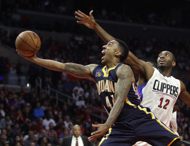 Indiana Pacers' Jeff Teague, center, shoots under pressure by Los Angeles Clippers' Luc Mbah a Moute during the second half of an NBA basketball game Sunday, Dec. 4, 2016, in Los Angeles. The Pacers won 111-102. AP 
