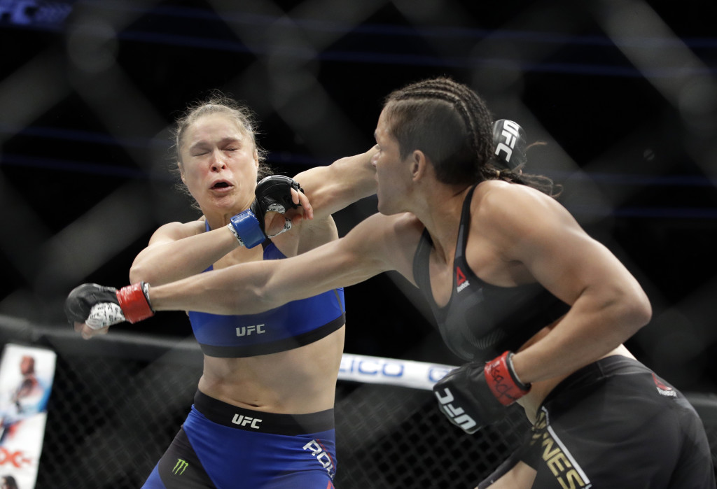 Amanda Nunes, right, throws a punch at Ronda Rousey in the first round of their women's bantamweight championship mixed martial arts bout at UFC 207, Friday, Dec. 30, 2016, in Las Vegas. Nunes won the fight after it was stopped in the first round. (AP Photo/John Locher)