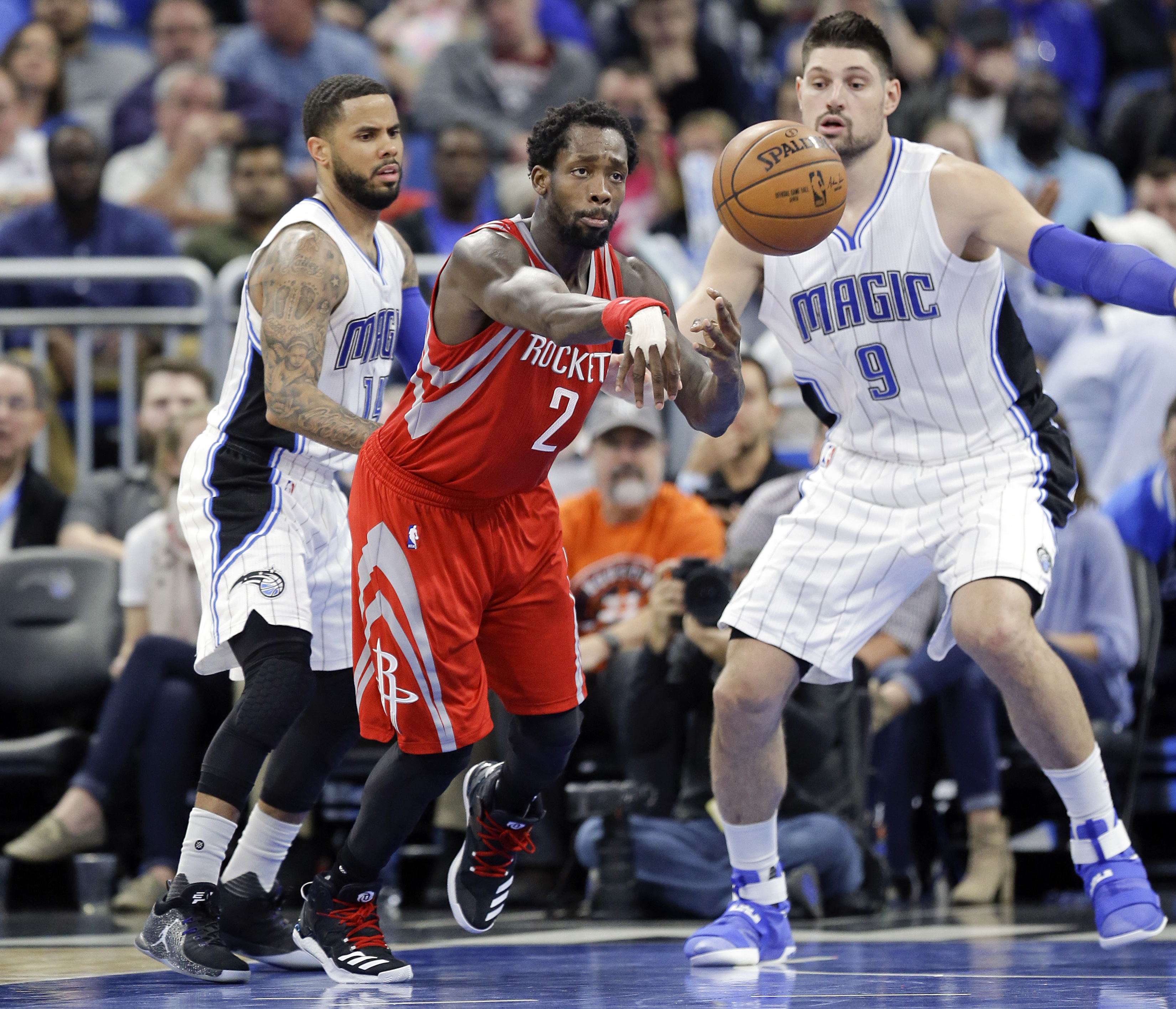 Houston Rockets' Patrick Beverley (2) passes the ball as he is guarded by Orlando Magic's D.J. Augustin, left, and Nikola Vucevic (9) during the second half of an NBA basketball game, Friday, Jan. 6, 2017, in Orlando, Fla. AP