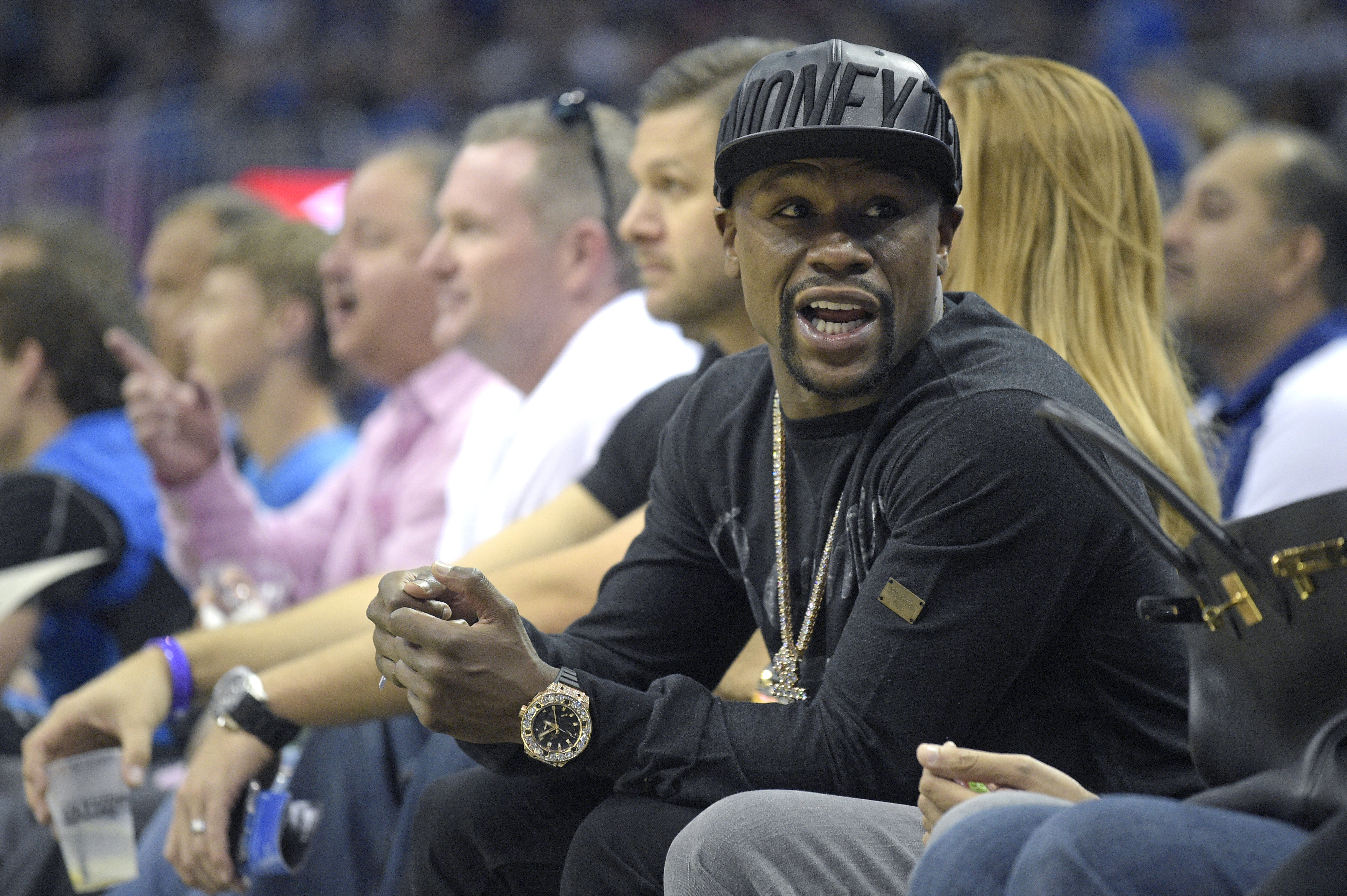 FILE - In this Oct. 30, 2015, file photo, boxer Floyd Mayweather Jr. talks to a fan while sitting court side during the first half of an NBA basketball game between the Orlando Magic and the Oklahoma City Thunder in Orlando, Fla. Mayweather Jr. wants attention more than he wants a fight. And, really, let's be truthful here. It wouldn't be much of a fight if Mayweather and Conor McGregor met in a boxing ring. (AP Photo/Phelan M. Ebenhack, File)