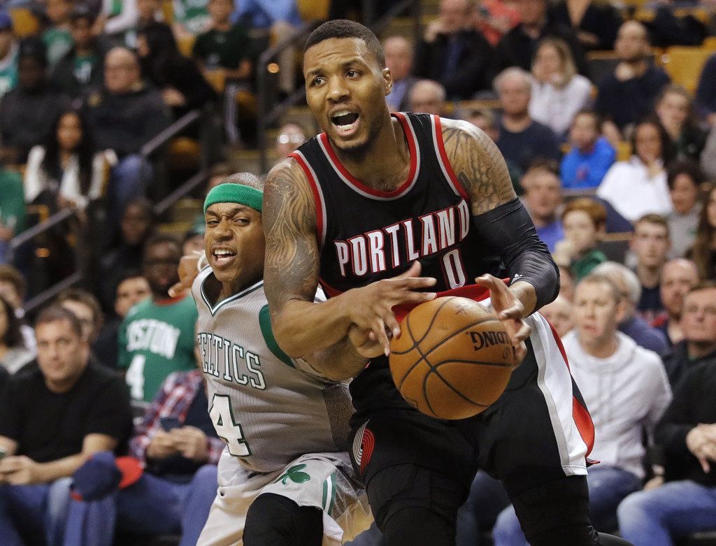 Boston Celtics' Isaiah Thomas reaches in to knock the ball away from Portland Trail Blazers' Damian Lillard (0) during the overtime of Portland's 127-123 win in an NBA basketball game in Boston Saturday, Jan. 21, 2017. (AP Photo/Winslow Townson)