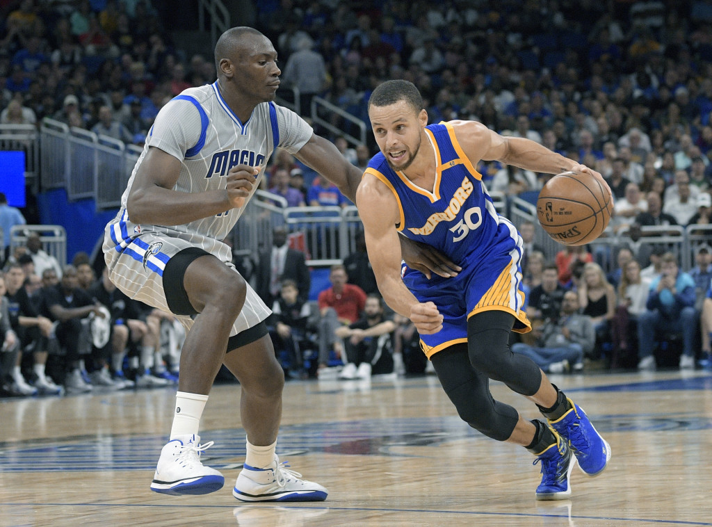Golden State Warriors guard Stephen Curry (30) drives to the basket in front of Orlando Magic center Bismack Biyombo during the first half of an NBA basketball game in Orlando, Fla., Sunday, Jan. 22, 2017. (AP Photo/Phelan M. Ebenhack)