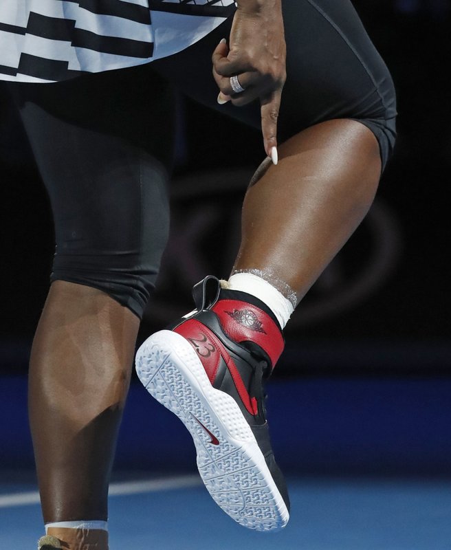 United States' Serena Williams points at shoes given to her by compatriot Michael Jordan to celebrate her 23rd Grand Slam title after defeating her sister Venus in the women's singles final at Australian Open tennis championships in Melbourne, Australia, Saturday, Jan. 28, 2017. (AP Photo/Kin Cheung) 