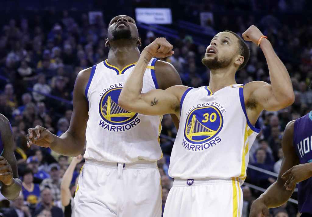 Golden State Warriors' Stephen Curry (30) reacts after a score from teammate Kevin Durant during the second half of the team's NBA basketball game against the Charlotte Hornets on Wednesday, Feb. 1, 2017, in Oakland, Calif. (AP Photo/Marcio Jose Sanchez)