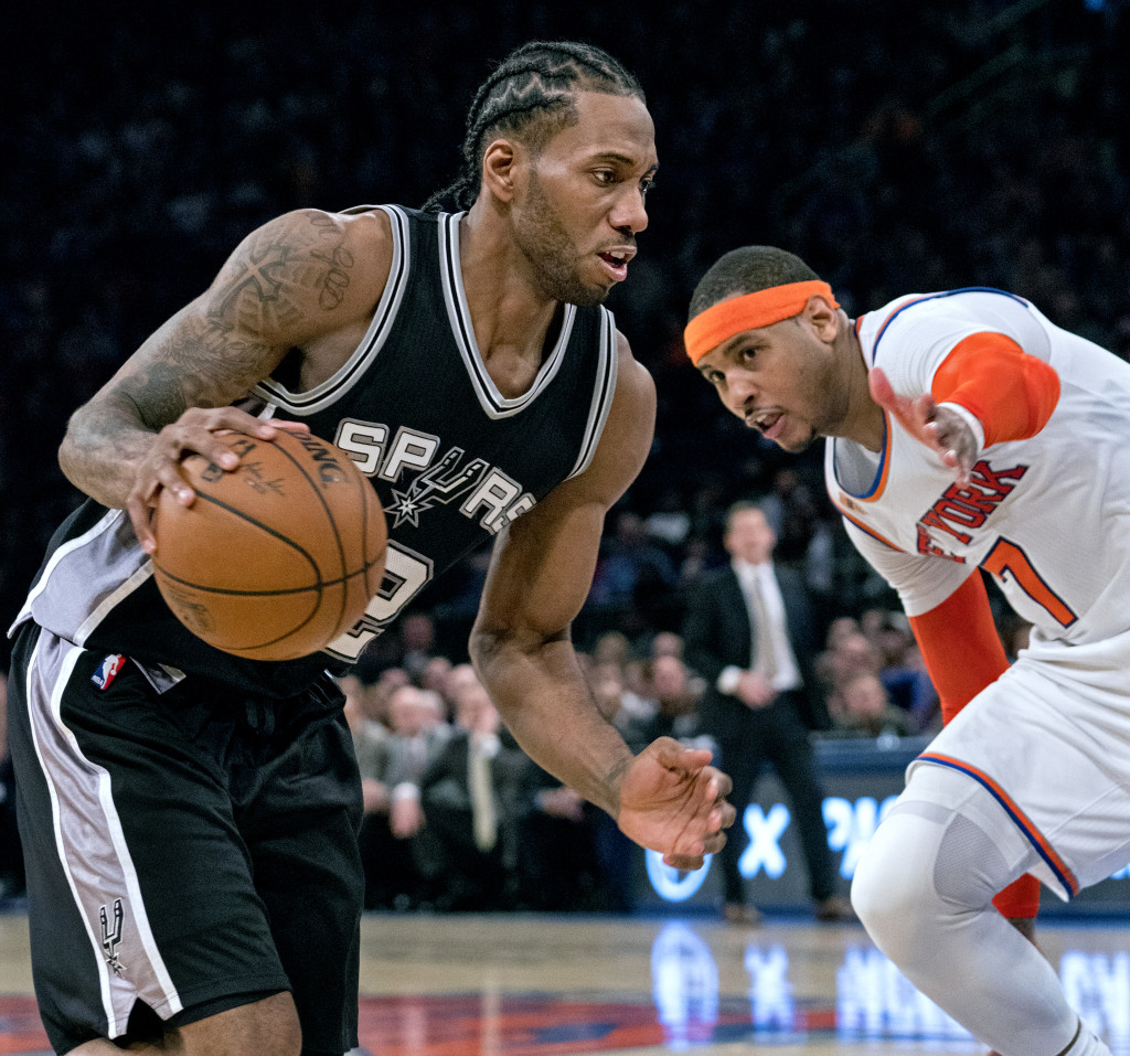 San Antonio Spurs froward Kawhi Leonard, left, drives to the basket past New York Knicks forward Carmelo Anthony in the second half of an NBA basketball game at Madison Square Garden in New York, Sunday, Feb. 12, 2017. (AP Photo/Craig Ruttle)