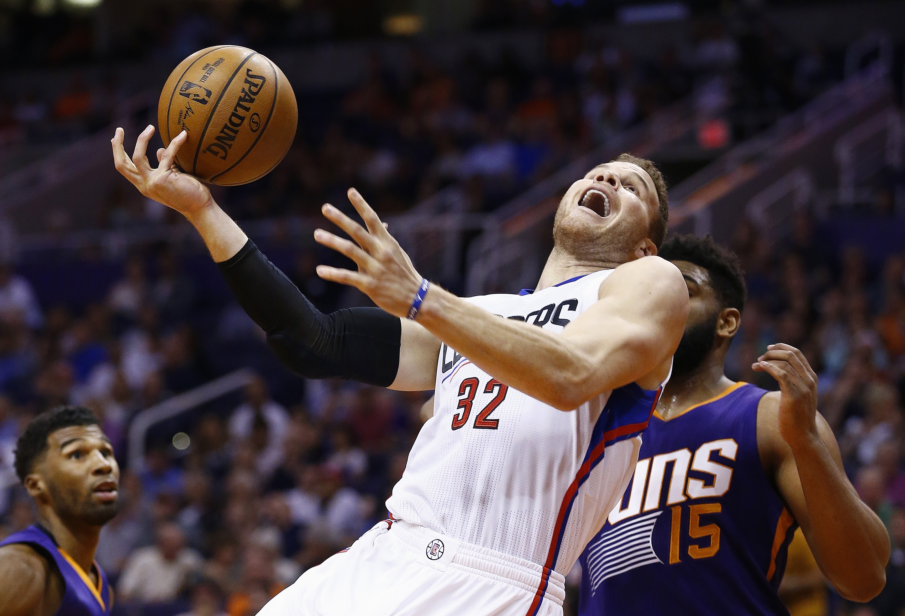 Los Angeles Clippers' Blake Griffin (32) tries to shoot over Phoenix Suns' Alan Williams (15) as Suns' Ronnie Price, left, looks on during the first half of an NBA basketball game Thursday, March 30, 2017, in Phoenix. (AP Photo/Ross D. Franklin)