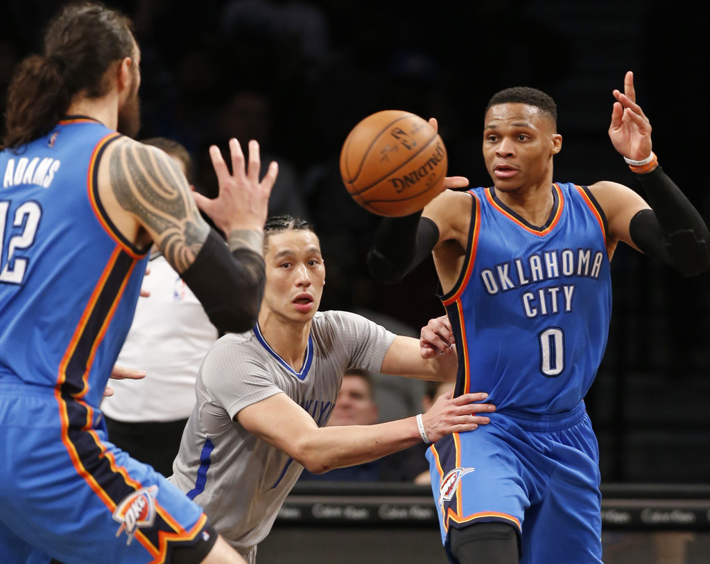 With Brooklyn Nets guard Jeremy Lin (7) defending, Oklahoma City Thunder guard Russell Westbrook (0) passes to Thunder center Steven Adams (12) in the second half of an NBA basketball game, Tuesday, March 14, 2017, in New York. The Thunder defeated the Nets 122-104. (AP Photo/Kathy Willens)