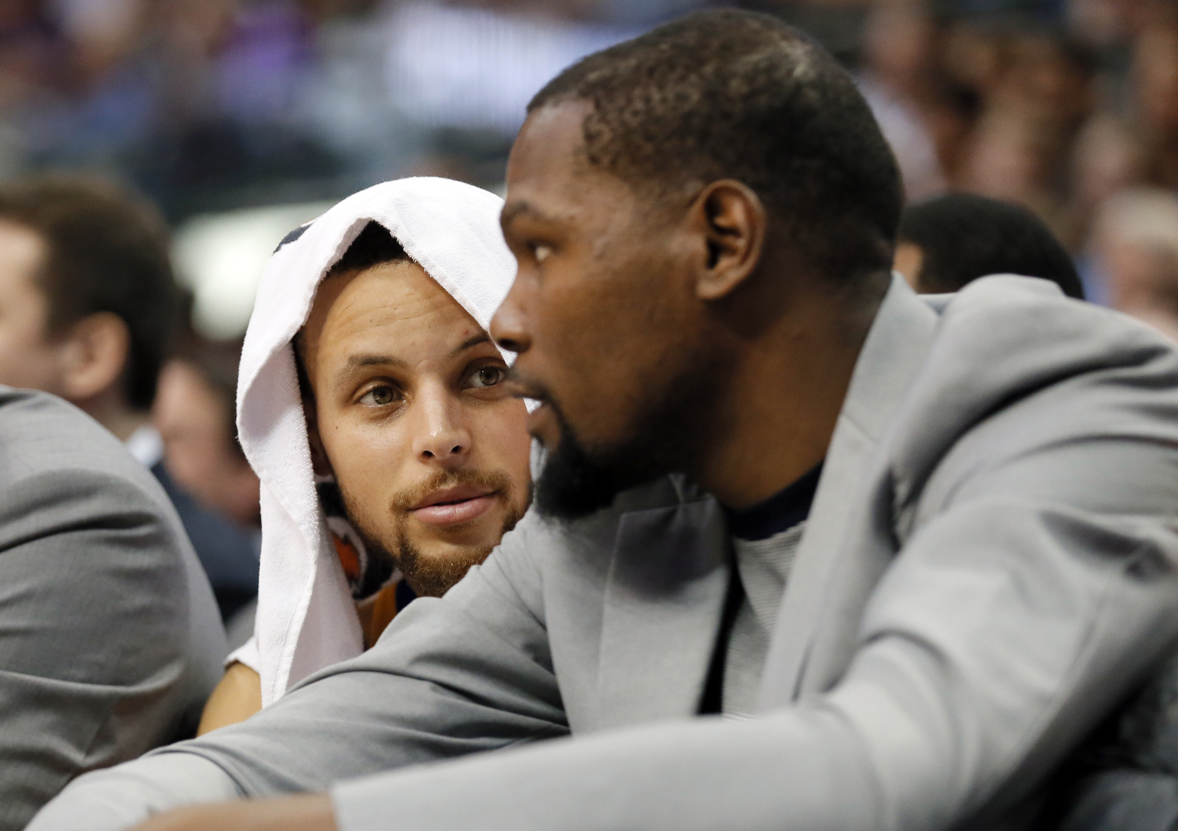 Golden State Warriors guard Stephen Curry, left, talks with Kevin Durant, right, in the first half of an NBA basketball game against the Dallas Mavericks on Tuesday, March 21, 2017, in Dallas. (AP Photo/Tony Gutierrez)