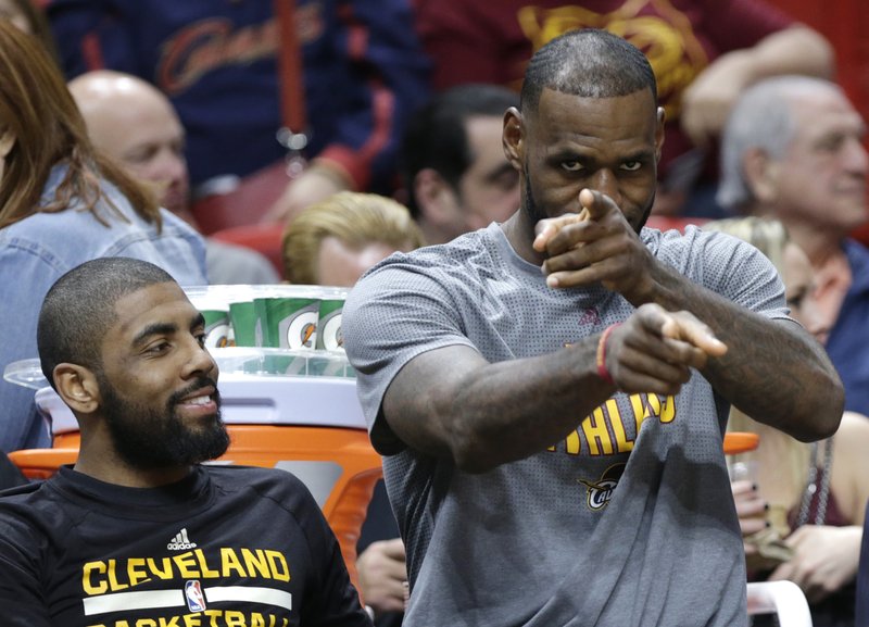 Cleveland Cavaliers' LeBron James, right, gestures as he sits with Kyrie Irving, left, on the bench during the first half of an NBA basketball game against the Miami Heat, Saturday, March 4, 2017, in Miami. (AP Photo/Lynne Sladky)