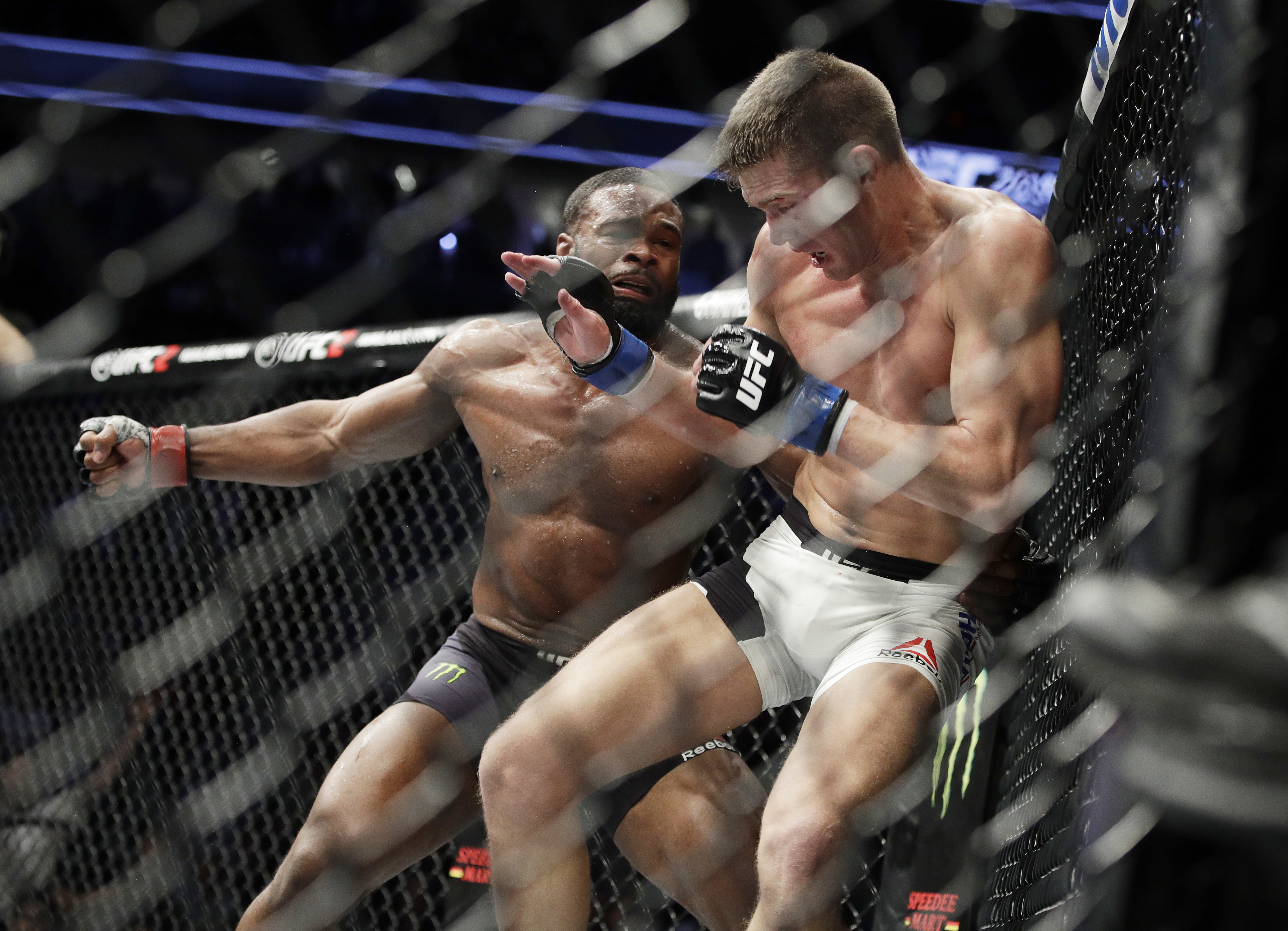 Tyron Woodley, left, takes a swing at Stephen Thompson in a welterweight championship mixed martial arts bout at UFC 209, Saturday, March 4, 2017, in Las Vegas. (AP Photo/John Locher)