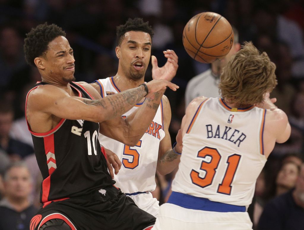 Toronto Raptors' DeMar DeRozan, left, fights for the ball with New York Knicks' Ron Baker, right, and Courtney Lee during the second half of the NBA basketball game, Sunday, April 9, 2017, in New York. The Raptors defeated the Knicks 110-97. (AP Photo/Seth Wenig)