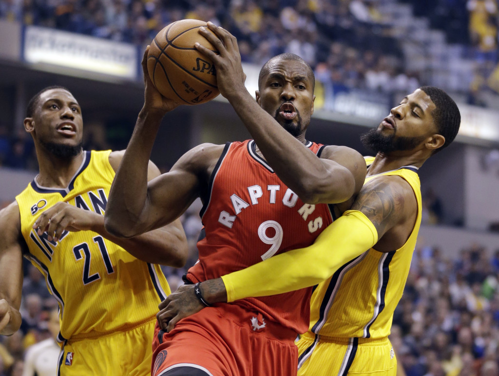 Indiana Pacers forward Paul George (13) fouls Toronto Raptors forward Serge Ibaka (9) during the first half of an NBA basketball game in Indianapolis, Tuesday, April 4, 2017. (AP Photo/Michael Conroy)