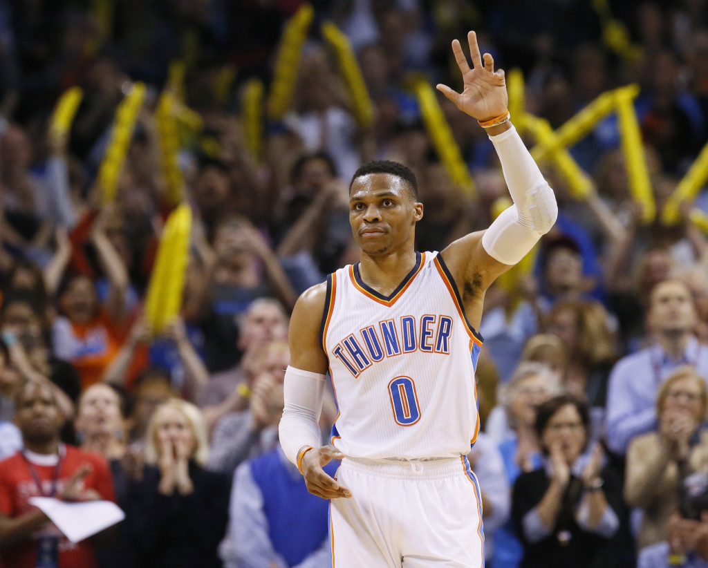 Oklahoma City Thunder guard Russell Westbrook (0) waves to the crowd after tying the record for triple-doubles in a season in the third quarter of an NBA basketball game against the Milwaukee Bucks in Oklahoma City, Tuesday, April 4, 2017. (AP Photo/Sue Ogrocki)