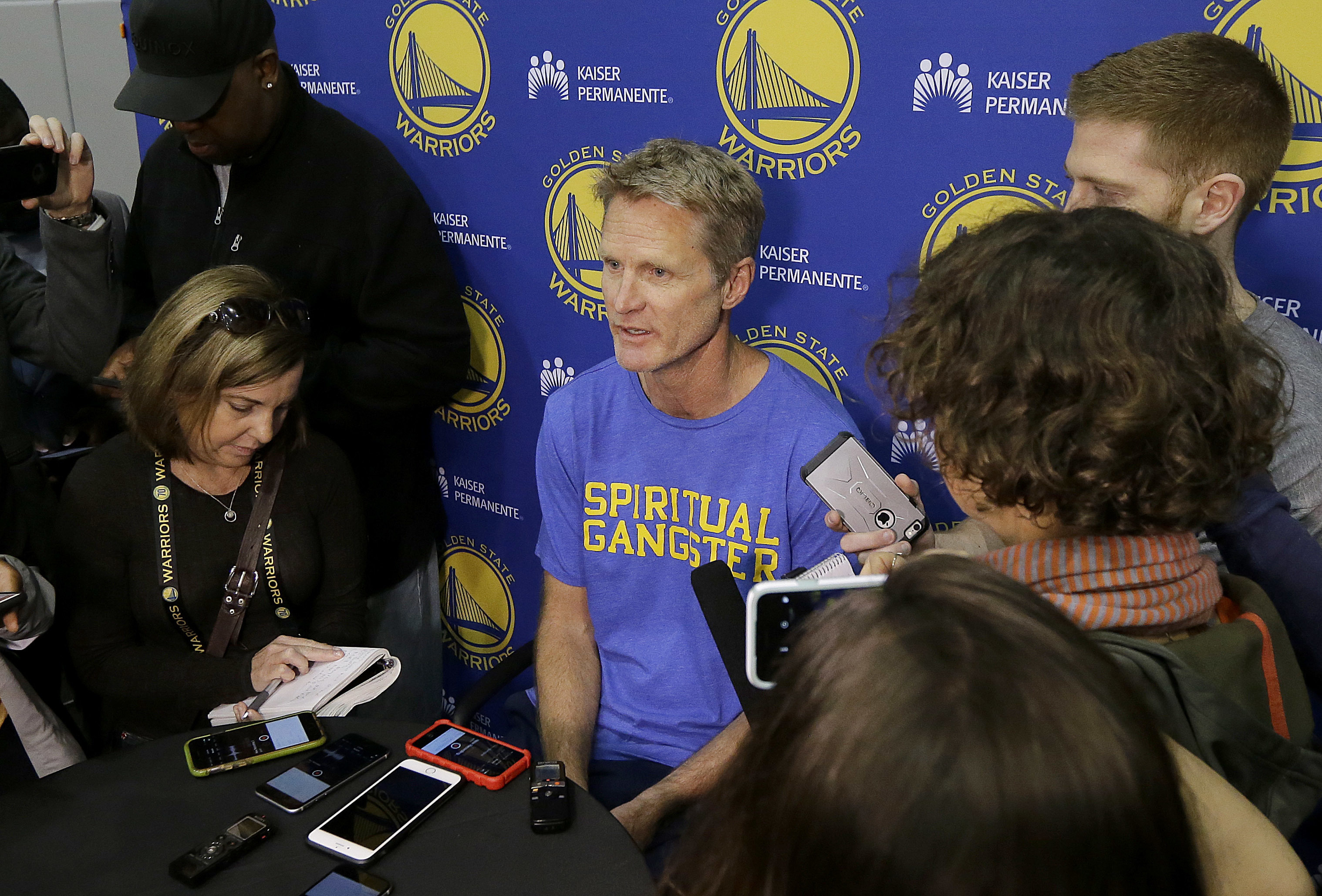 FILE - In this April 7, 2017, file photo, Golden State Warriors head coach Steve Kerr, center, speaks during NBA basketball practice in Oakland, Calif. The Warriors return to the practice court following a day off after their first-round sweep of Portland, with coach Kerr's health status still unclear.  (AP Photo/Jeff Chiu, File)