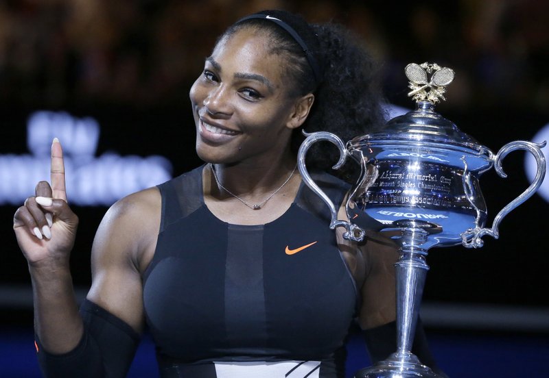 FILE - In this Jan. 28, 2017, file photo, Serena Williams holds up a finger and her trophy after defeating her sister, Venus, in the women's singles final at the Australian Open tennis championships in Melbourne, Australia. 