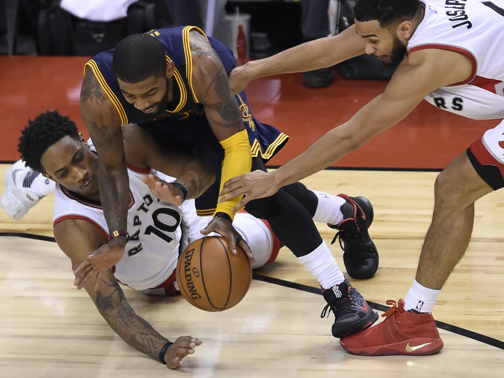 Cleveland Cavaliers guard Kyrie Irving (2) is fouled by Toronto Raptors guard DeMar DeRozan (10) as Raptors guard Cory Joseph (6) reaches in during the second half of Game 4 of a second-round NBA basketball playoff series in Toronto, Sunday, May 7, 2017. (Nathan Denette/The Canadian Press via AP)