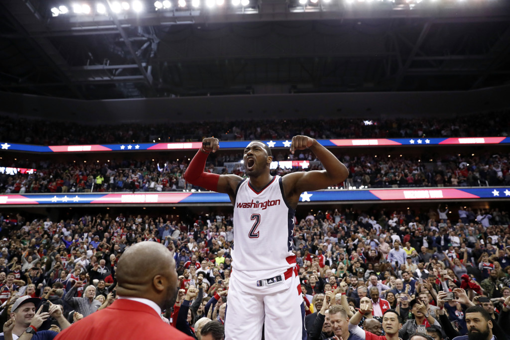 Washington Wizards guard John Wall celebrates as he stands on the scorer's table after Game 6 against the Boston Celtics in an NBA basketball second-round playoff series, Friday, May 12, 2017, in Washington. Wall sank the game-winning 3-point shot. The Wizards won 92-91. (AP Photo/Alex Brandon)