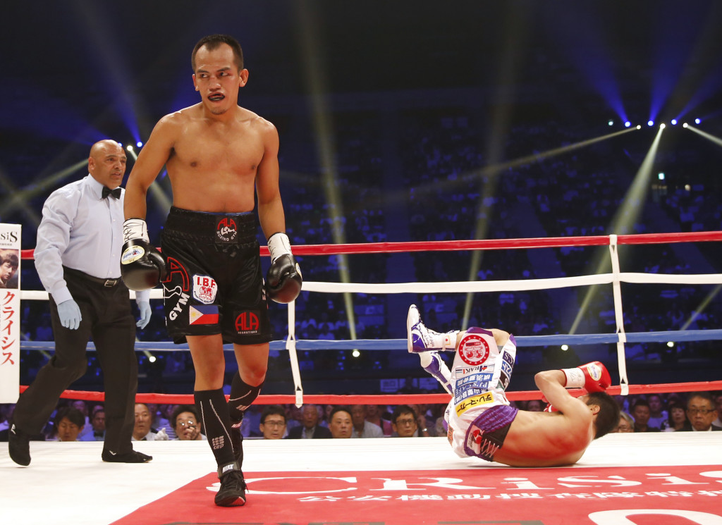 Philippine interim champion Milan Melindo walks back to a corner as Japanese champion Akira Yaegashi falls down on the mat after being knocked down in the first round of their IBF light flyweight boxing unified champion match in Tokyo, Sunday, May 21, 2017. Melindo knocked out Yaegashi in the round to win the title. (AP Photo/Toru Takahashi)