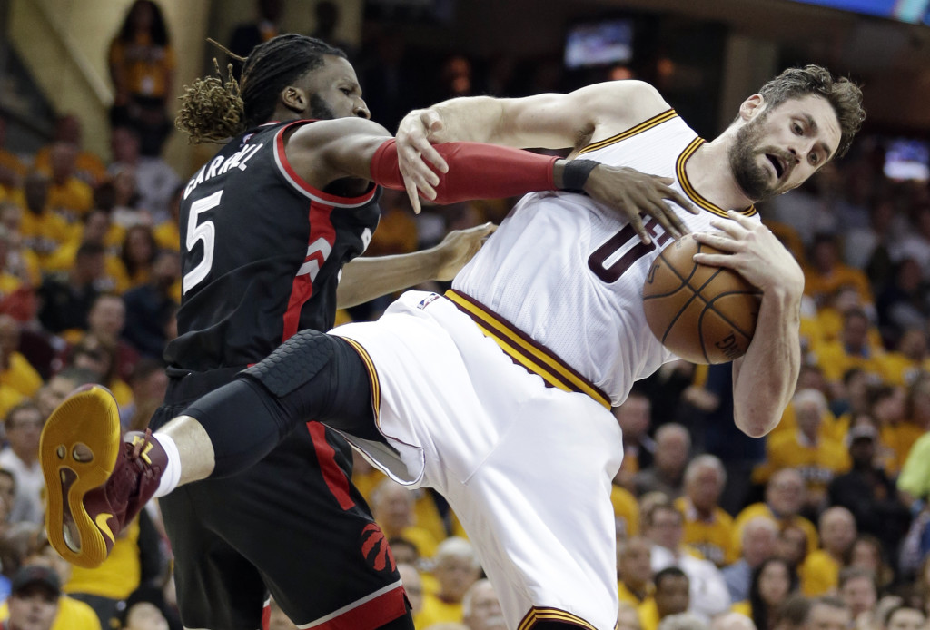 Toronto Raptors' DeMarre Carroll (5) puts pressure on Cleveland Cavaliers' Kevin Love (0) in the first half in Game 1 of a second-round NBA basketball playoff series, Monday, May 1, 2017, in Cleveland. (AP Photo/Tony Dejak)