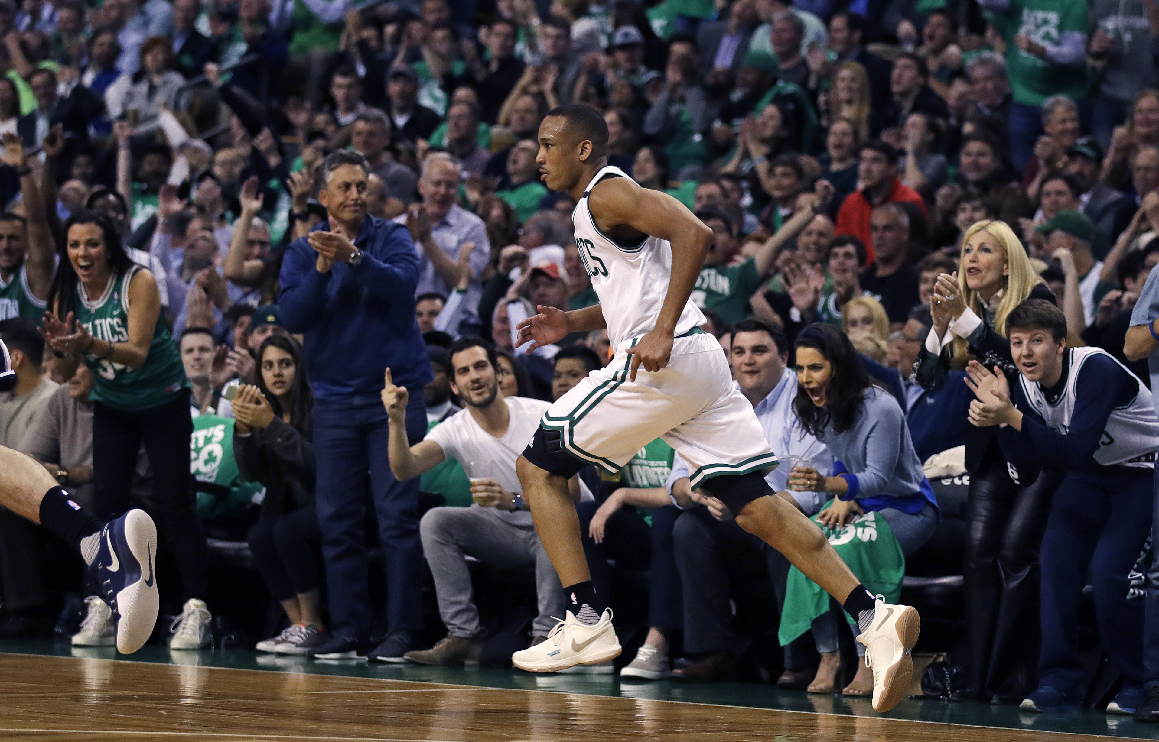 Fans cheer as Boston Celtics guard Avery Bradley heads down court after hitting a 3-pointer during the second quarter of Game 5 of an NBA basketball second-round playoff series in Boston, Wednesday, May 10, 2017. Bradley scored 29 as the Celtics defeated the Washington Wizards 123-101. (AP Photo/Charles Krupa)