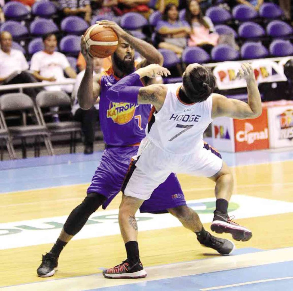 Mo Tautuaa of TNT charges into Cliff Hodge of Meralco during Monday night’s quarterfinal duel between both squads.  —AUGUST DELA CRUZ