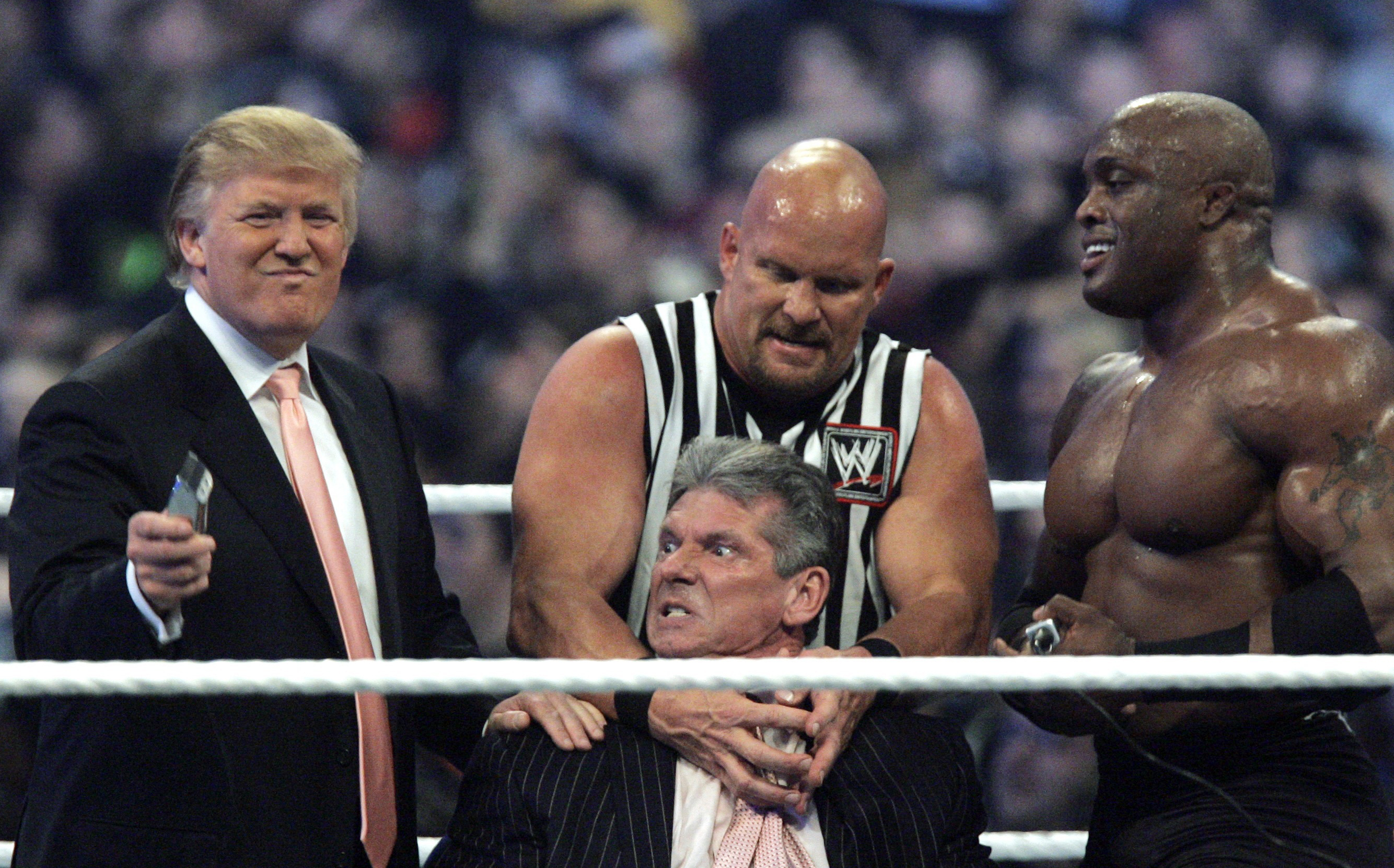 FILE - In this Sunday, April 1, 2007, file photo, WWE Chairman Vince McMahon, center, held by "Stone Cold" Steve Austin, prepares to have his hair cut off by Donald Trump, left, and Bobby Lashley, right, after Lashley defeated Umaga at Wrestlemania 23 at Ford Field in Detroit. 