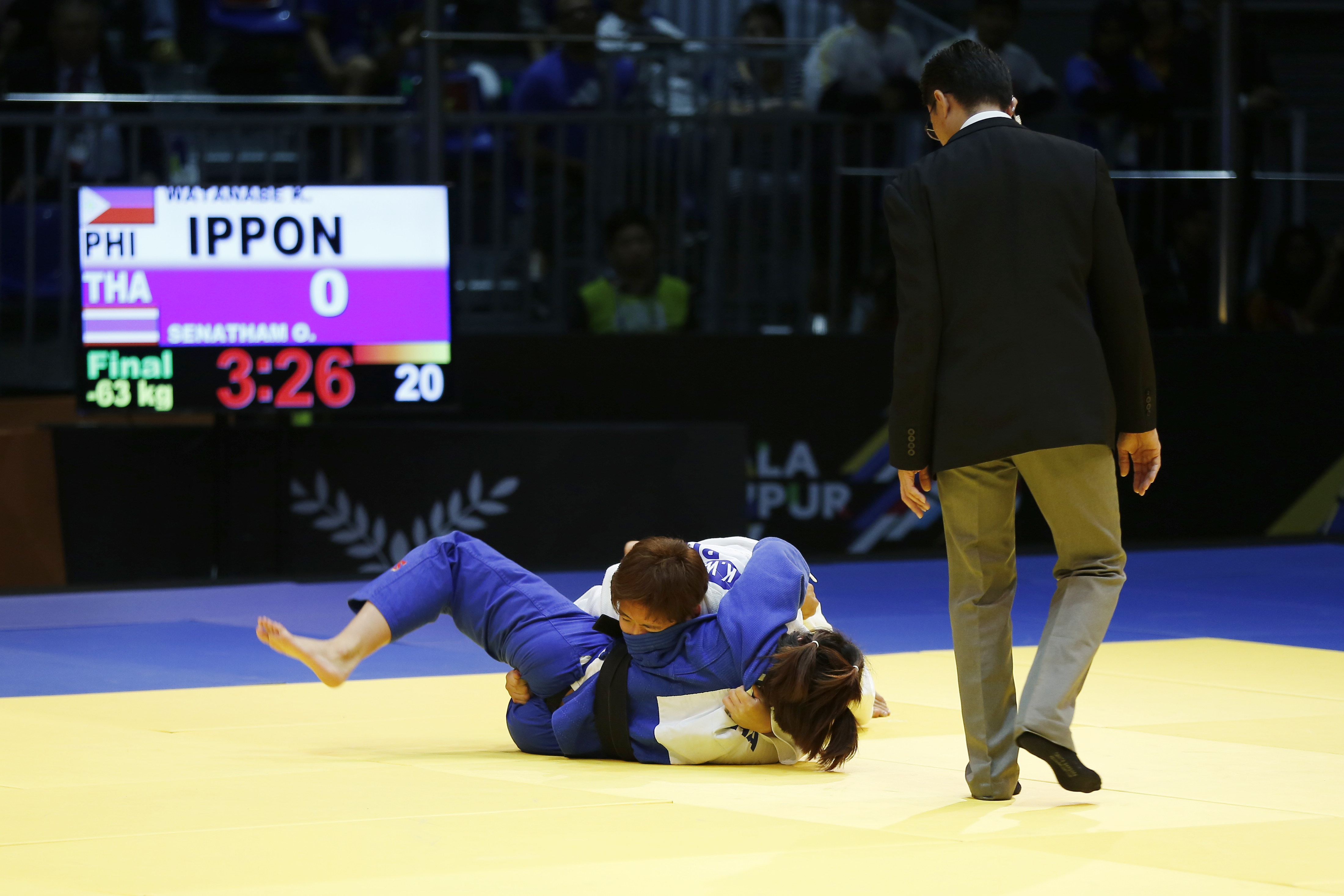 Kiyomi Watanebe of the Philippines (white) competes against Oran Senetham of Thailand (blue) in the women's 63kg class of the 29th Southeast Asian Games judo competition