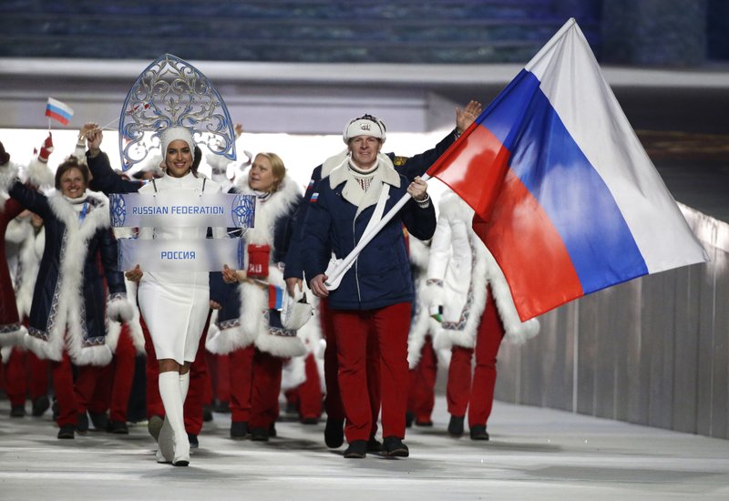 Alexander Zubkov of Russia carries the national flag as he leads the team during the opening ceremony of the 2014 Winter Olympics in Sochi, Russia. Four more Russians were disqualified for doping at the Sochi Olympics shortly after IOC President Thomas Bach told critics not to put pressure on his executive board before a key decision next month on the country’s participation at the Pyeongchang Games. Two-time bobsled gold medalist Alexander Zubkov was removed from the 2014 records by the IOC for links to a widespread doping program. 