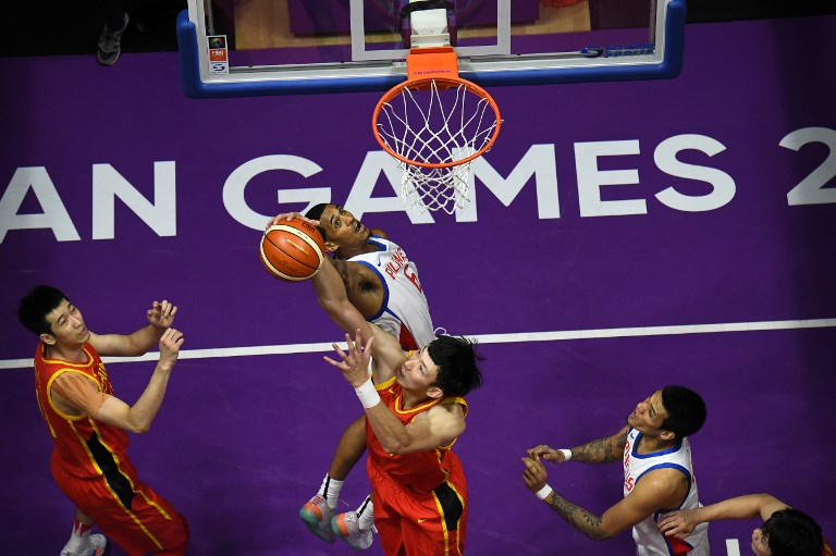 China's Zhou Qi (bottom C) blocks a shot by the Philippines' Jordan Clarkson (top C) in their men's basketball preliminary Group D game between China and the Philippines during the 2018 Asian Games in Jakarta on August 21, 2018. 