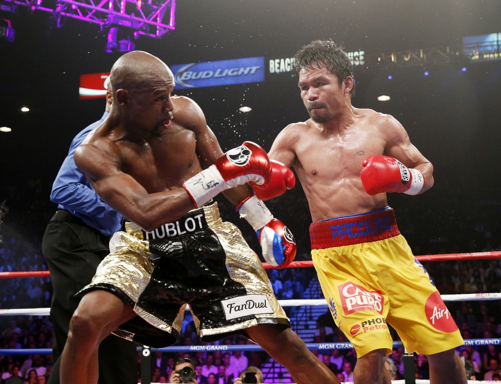 Floyd Mayweather Jr. exchange punches with Manny Pacquiao during their welterweight unification championship bout, May 2, 2015 at MGM Grand Garden Arena in Las Vegas, Nevada. Mayweather defeated Pacquiao by unanimous decision. AFP PHOTO / JOHN GURZINKSI (Photo by JOHN GURZINSKI / AFP)