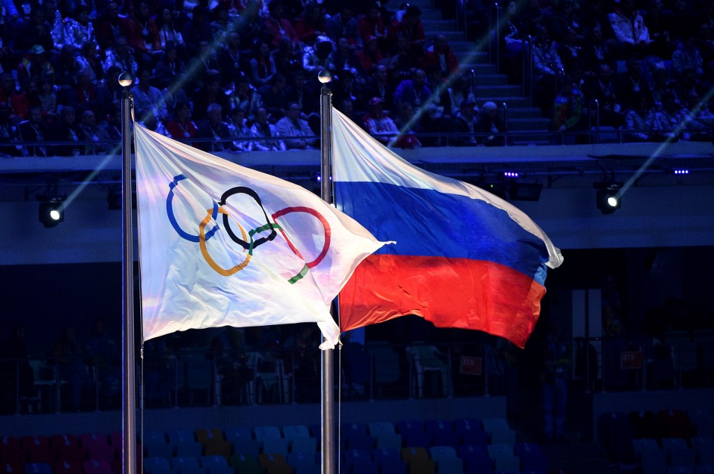 (FILES) This file photo taken on February 23, 2014 shows the Olympic flag and the Russian flag flying during the Closing Ceremony of the Sochi Winter Olympics at the Fisht Olympic Stadium. 