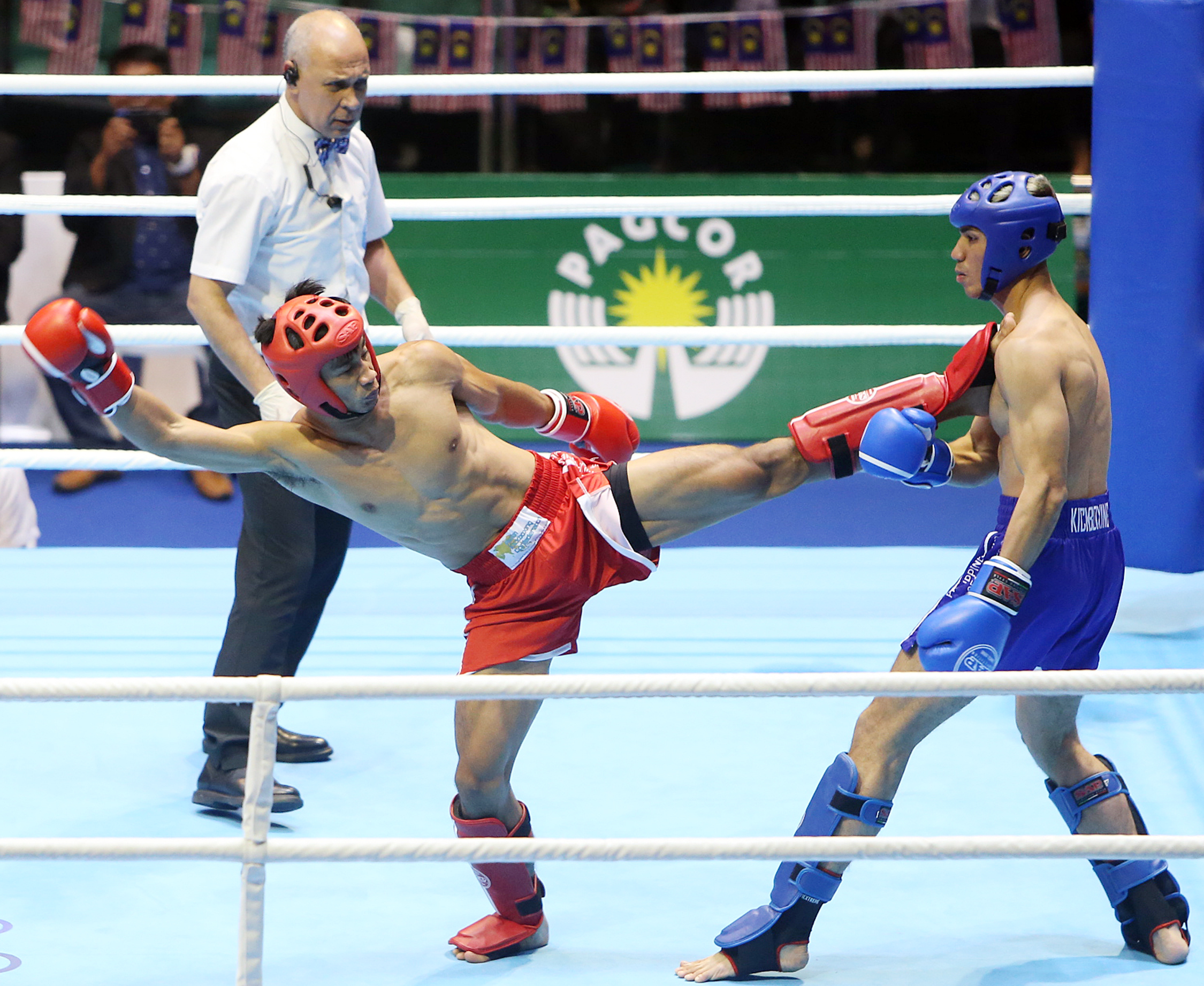 Jean-Calwood Saclog (red) of the Philippines delivers a left kick to the chest of his opponent Muhammad Mahmood (blue) of Malaysia during their kickboxing match at the Cuneta Astrodome on December 10, 2019.  Saclag went on to win the gold medal.  Edwin Bekasmas