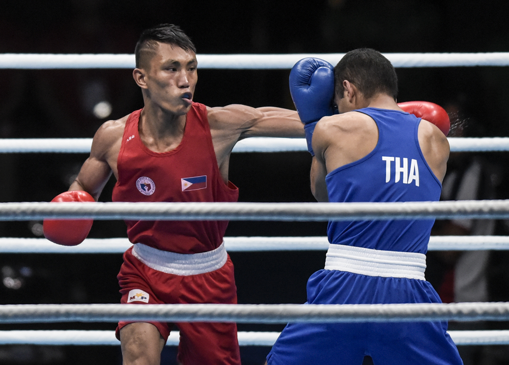 Rogen Ladon throws punches against Thailand’s Ammarit Yaodam in the 30th Southeast Asian Games boxing final.