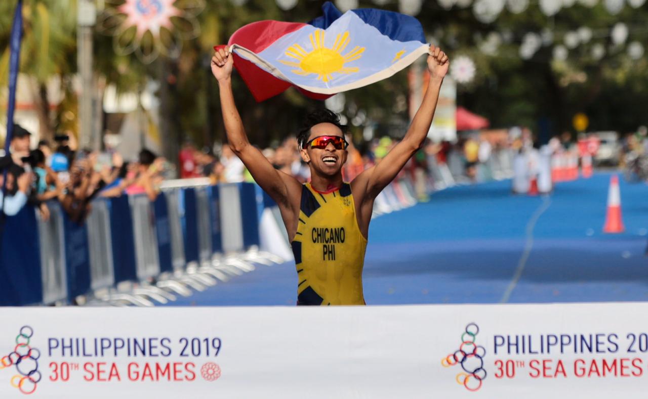 Filipino triathlete John Leerams Chicano crosses the finish line waving the Philippine flag proudly to win gold in the men's triathlon at the 2019 30th SEA games at Subic, Zambales.