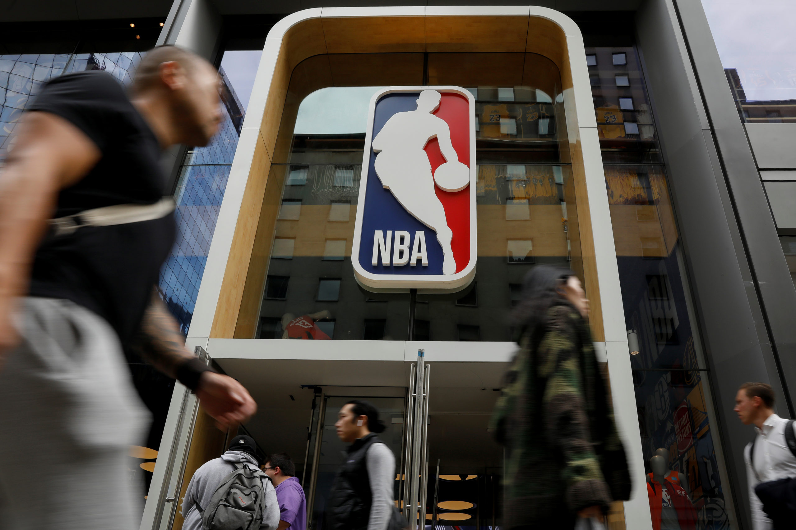 The NBA logo is displayed as people pass by the NBA Store in New York